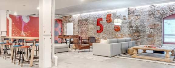 A room with a brick wall and a white column.
