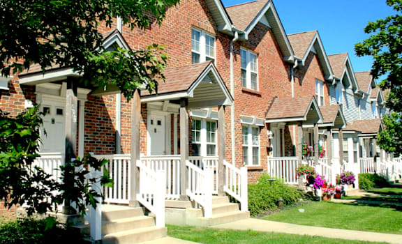 A row of houses with white fences and flower pots.