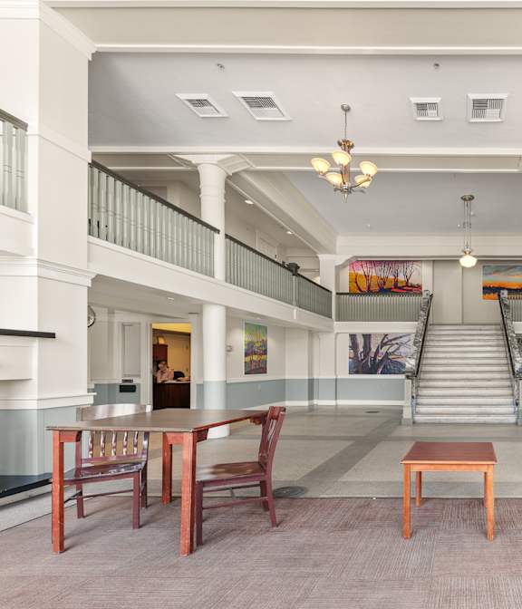 A large room with tables and chairs and a staircase at 206 Flats, Spokane, WA