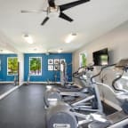 a gym with weights and a ceiling fan at The Entro at Midtown, Dallas