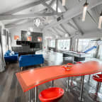 a living room with a red table and a pool table