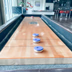 a shuffleboard table in a restaurant with four blue caps on it  at Vibe on Riverside, Austin, Texas