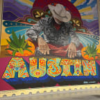 a mural of a man sitting at a table with a sign that says usa  at Vibe on Riverside, Austin