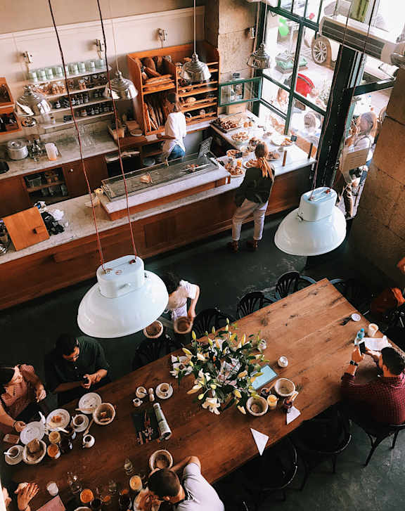 A group of people are sitting at a long table in a restaurant.