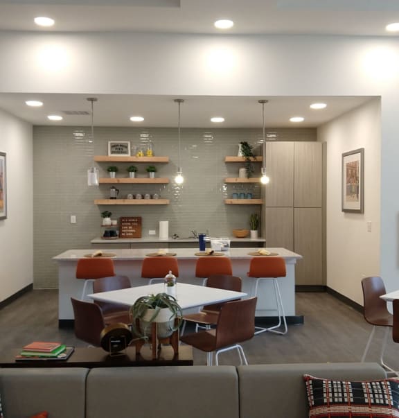 a dining room with tables and chairs and a kitchen