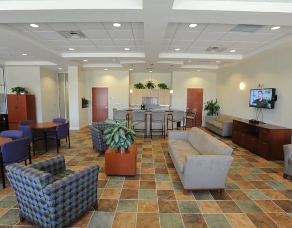 a lobby with couches chairs and tables and a tv