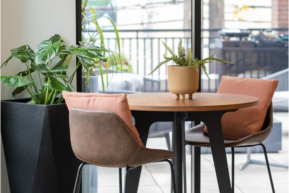 A table with two chairs and a potted plant on top of it at Kesler Apartments in Downtown Fargo, Fargo, ND 58102