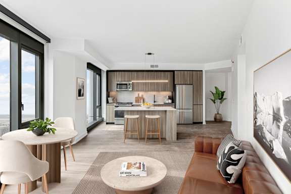 A modern living room with a dining area and kitchen in the background.