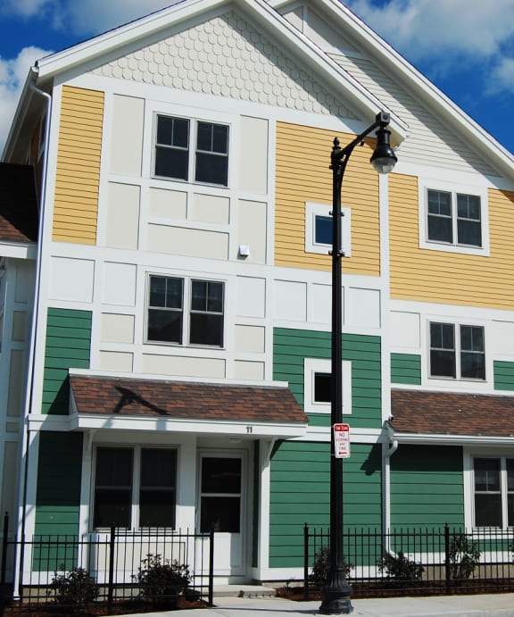a white house with green and yellow siding and a street light