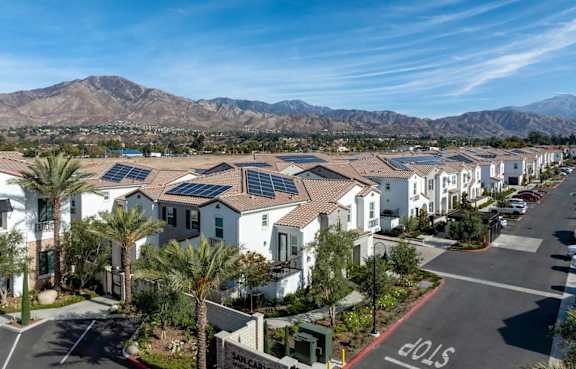 A residential area with houses and solar panels on the roofs.