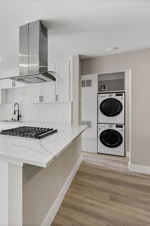 A modern kitchen with white cabinets and stainless steel appliances.