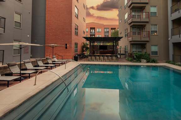 A swimming pool in front of apartment buildings.