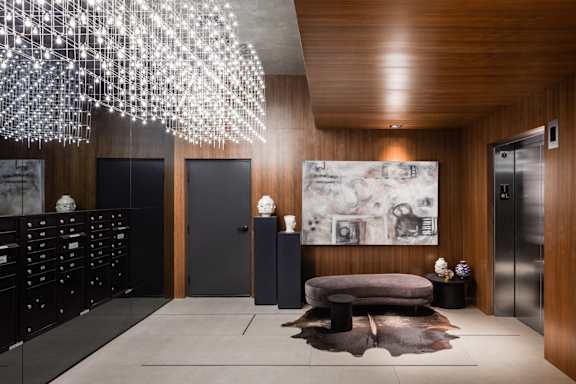 the lobby of a building with a chair and a chandelier