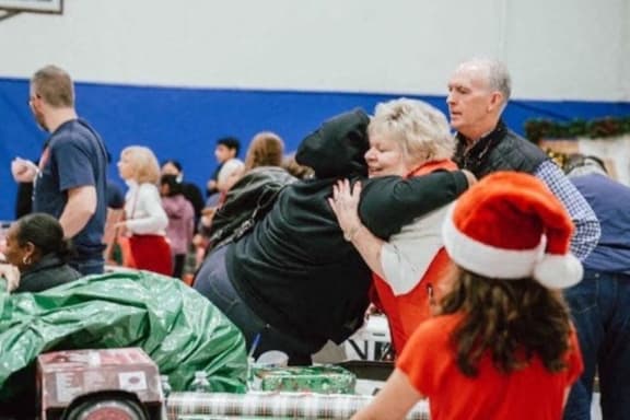 a woman hugging a dog in a crowd of people