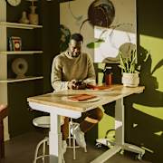 Man sitting at a table using phone at Scout Living, powered by Placemakr, Atlanta, GA