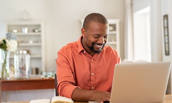Man Smiling While Working on Computer