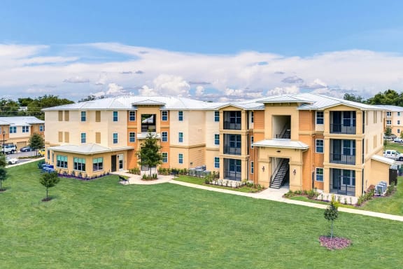 an aerial view of an apartment building with a green lawn
