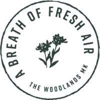 A black and white logo for Breath of Fresh Air featuring flowers at The Woodlands Apartments, Milton Keynes