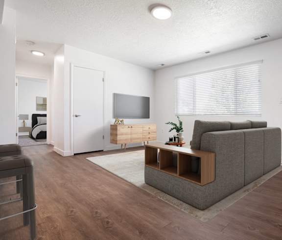A living room with a grey couch and a wooden coffee table.