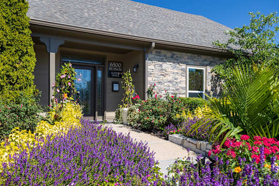 The Cedar Crest Apartments clubhouse exterior with a well-maintained front entrance and neatly landscaped greenery.