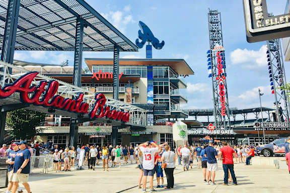 A large crowd of people are gathered outside of the Atlanta Braves stadium.