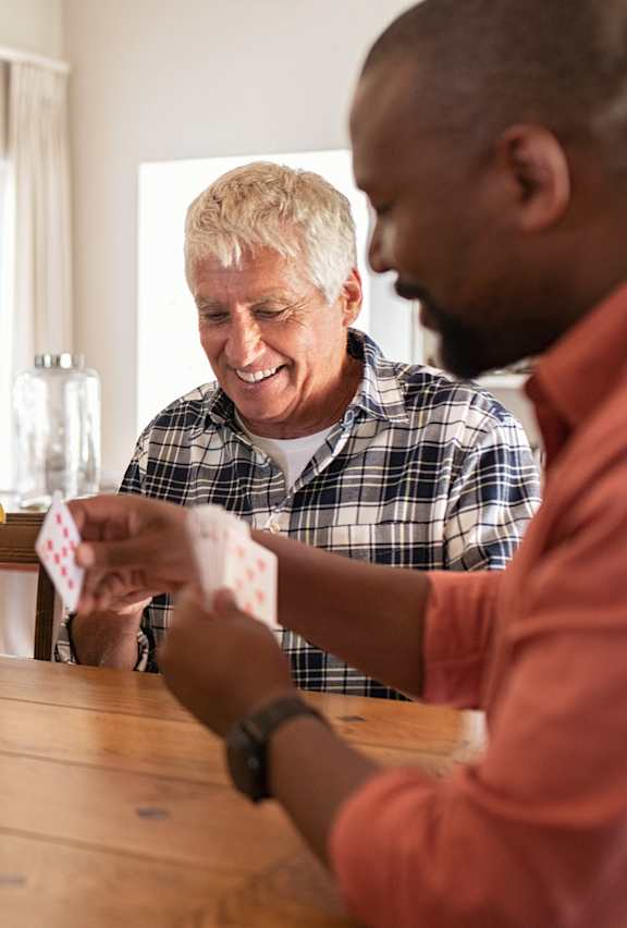 A group of people playing a card game at a table.