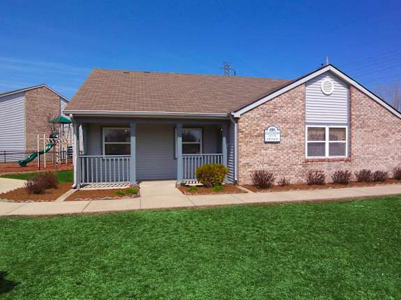 a home with a green lawn and blue sky in the background