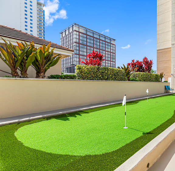 A miniature golf course is situated in the courtyard of a residential building.