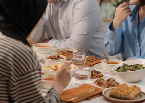 A group of people are sitting around a table eating a meal.