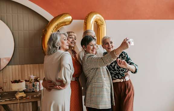 Three people sitting on a couch in a living room.