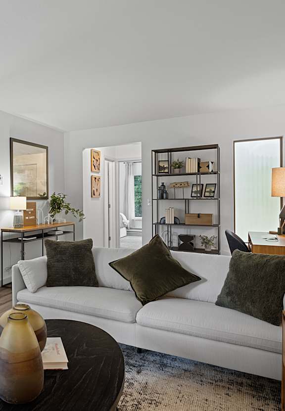 A living room with a white couch and a wooden coffee table.