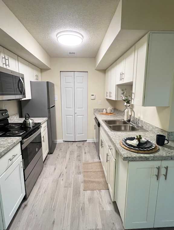 A modern kitchen with a clock on the wall and a round window.
