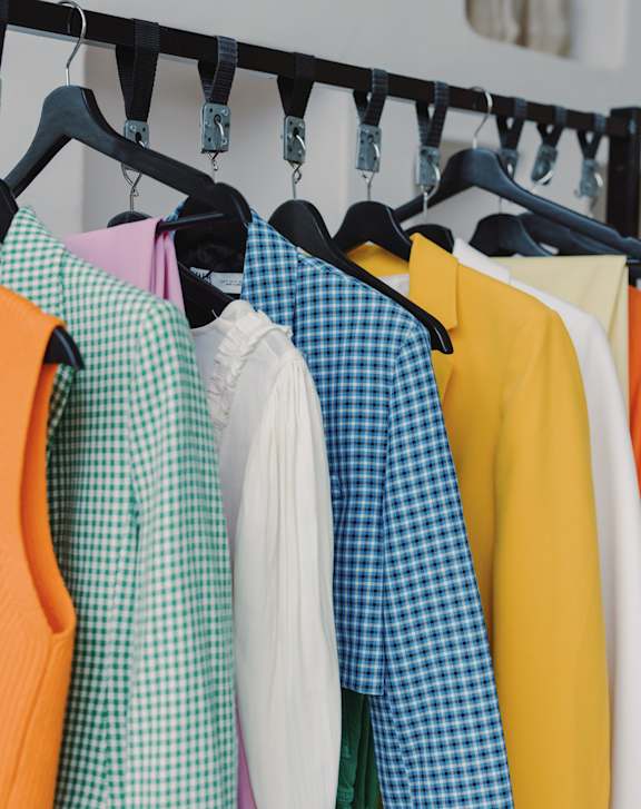 Clothes hanging on a rack with a white background.