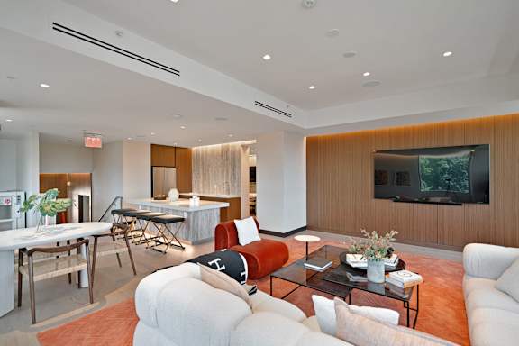 A modern living room with a television and a dining table.