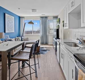 A kitchen with a dining table and chairs.
