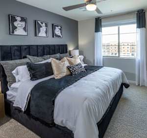 A bedroom with a large bed and a ceiling fan.