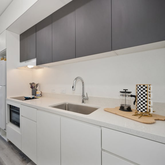 an open kitchen with white cabinets and a stainless steel sink