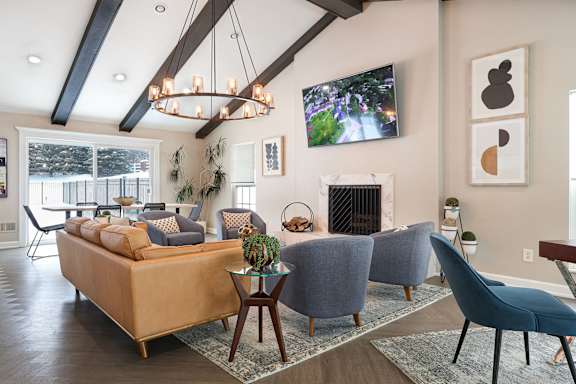 A modern dining room with a stone fireplace and a chandelier.