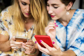Two individuals glancing at their phones