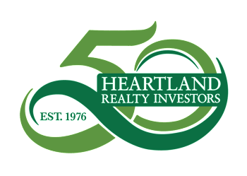 The image is a logo for Heartland Realty Investors, established in 1976.