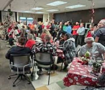 a large group of people sitting at tables at a christmas party