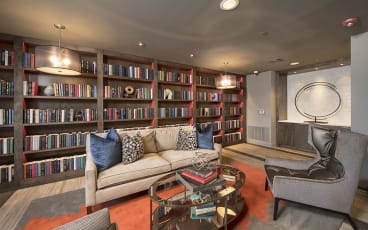 a living room filled with furniture and a large book shelf