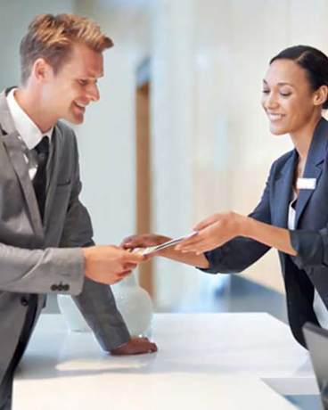 a man and woman in business attire shaking hands at The Trilogy Apartments, Manchester, M15 4RU