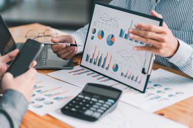 A person is analyzing a financial report with various charts and graphs.