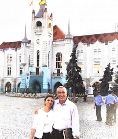 a man and a woman standing in front of a building