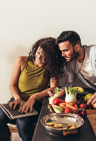 Couple looking at laptop in kitchen