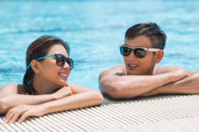a man and woman in a swimming pool wearing sunglasses