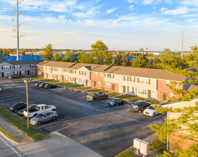 an aerial view of an apartment complex with cars parked in a parking lot