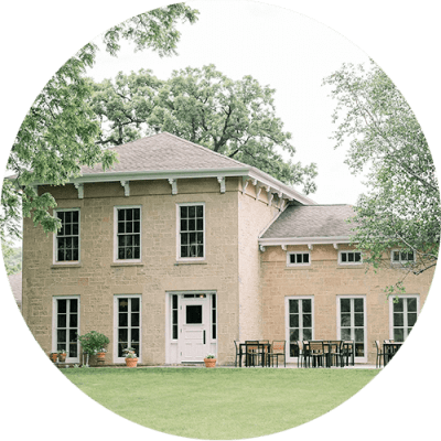 the exterior of a brick house with a lawn and trees
