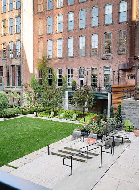 A green lawn in front of a red brick building.